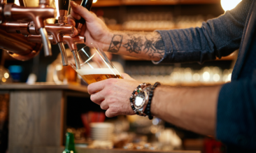 Man pouring pint after learning how to make a bar profitable