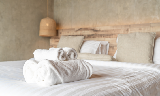 Freshly made hotel bed with towels