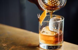 a bartender pouring a freshly mixed cocktail.